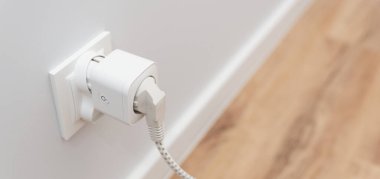 Akıllı bir evde duvarda kablosuz ağ akıllı soketi kullanmak, elektrik tüketimini kontrol etmek.