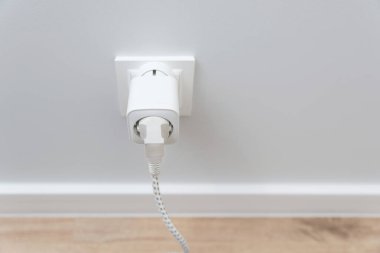 Akıllı bir evde duvarda kablosuz ağ akıllı soketi kullanmak, elektrik tüketimini kontrol etmek.