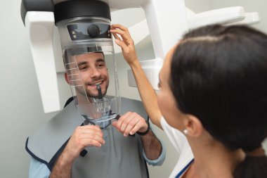 Hasta röntgen makinesinde duruyor. Profesyonel diş kliniğinde panoramik radyografi.