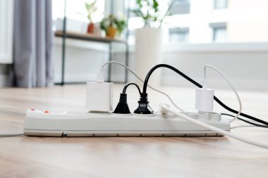 Elektrik prizi birden fazla prize takıldı. Elektrik ekipmanları, elektrik kabloları ve elektrik bantları evde.
