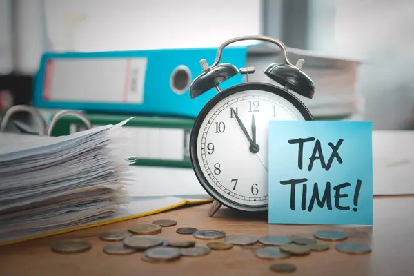 Income tax concept with clock and papers