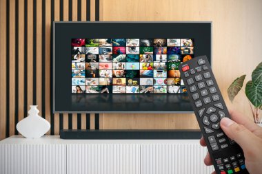 VOD servis ekranı. Adam elle uzaktan kumanda ile TV izlerken.