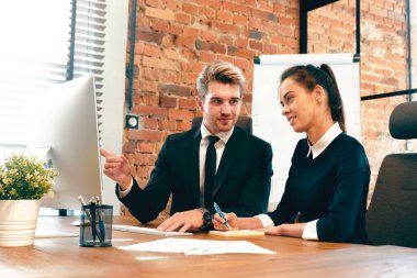 Çalışanlar ofiste çalışır, iş arkadaşları ortak bir proje üzerinde çalışır.
