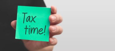 Vergi zaman dilimli yapışkan notlar tutan bir adam. Vergi geliri ve geri ödeme kavramı