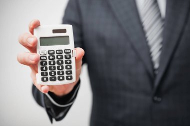 Hesap makinesi tutan iş adamı ya da muhasebeci. Finans kavramı