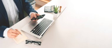 Ofiste dizüstü bilgisayarla çalışan bir iş adamı. Fotokopi alanı afişi olan geniş resim