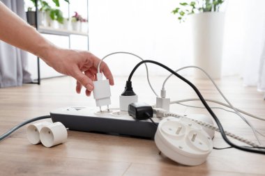 Elektrik prizini takan adam. Evdeki prizin prizine elektrik prizi takın.