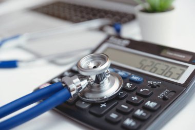 Steteskoplu bir hesap makinesi. Sağlık sigortası, tıbbi maliyet konsepti