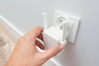 Beyaz duvarda kablosuz kablosuz kablosuz ağ yineleyici var. Wi-Fi genişletici