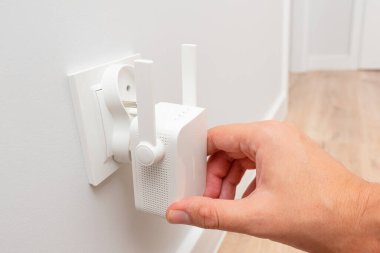 Beyaz duvarda kablosuz kablosuz kablosuz ağ yineleyici var. Wi-Fi genişletici