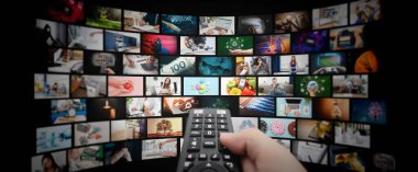 Küçük ekranlı medya konsepti video duvarı, yayın servisi veya VOD konsepti. Uzaktan kumanda elinde