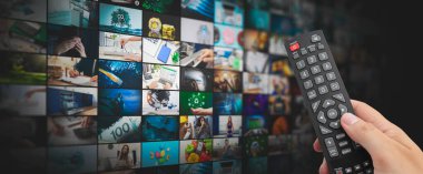 Küçük ekranlı medya konsepti video duvarı, yayın servisi veya VOD konsepti. Uzaktan kumanda elinde
