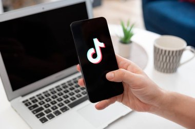 Wroclaw, Polonya - 17 Ocak 2025: Ekranda TikTok logosu. TikTok servisini kullanan adam