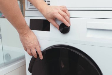 Bir çamaşır odasında beyaz çamaşır makinesi. Ev işleri konsepti