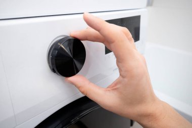 Bir çamaşır odasında beyaz çamaşır makinesi. Ev işleri konsepti