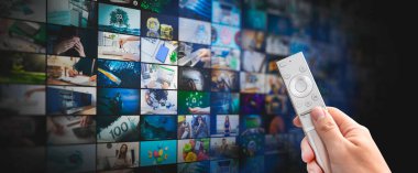 Küçük ekranlı medya konsepti video duvarı, yayın servisi veya VOD konsepti. Uzaktan kumanda elinde