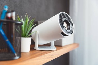 Rafında lens olan kablosuz beyaz projektör.