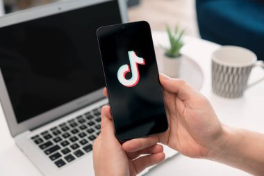 Wroclaw, Polonya - 17 Ocak 2025: Ekranda TikTok logosu. TikTok servisini kullanan adam