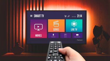 Televizyon izleyen adam, uzaktan kumanda elinde. TV 'de VOD hizmeti