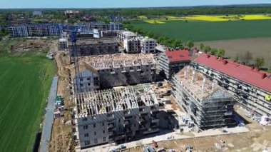 Wroclaw, Polonya - APR 26, 2025: Vinçleri ve tamamlanmamış binaları olan bir yerleşim alanının havadan görünüşü