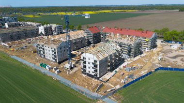 Wroclaw, Polonya - APR 26, 2025: Vinçleri ve tamamlanmamış binaları olan bir yerleşim alanının havadan görünüşü