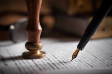 Hukuk, noter teması. Masada dolmakalem ve el yapımı kağıt var.