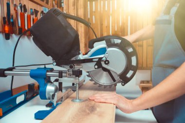 Marangoz döşeme panelleri üzerinde çalışırken testere kullanıyor.