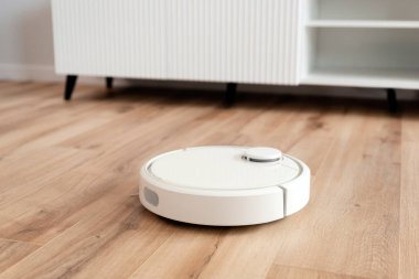 Beyaz robot aşı temizleyicisi oturma odasında yerde, akıllı ev aleti