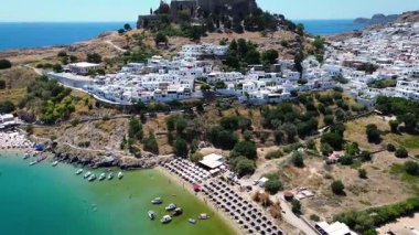 Tepedeki Lindos kasabası. Turkuaz deniz kıyısında altın plaj.