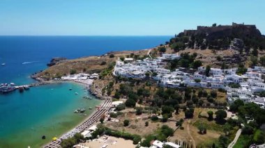 Tepedeki Lindos kasabası. Turkuaz deniz kıyısında altın plaj.