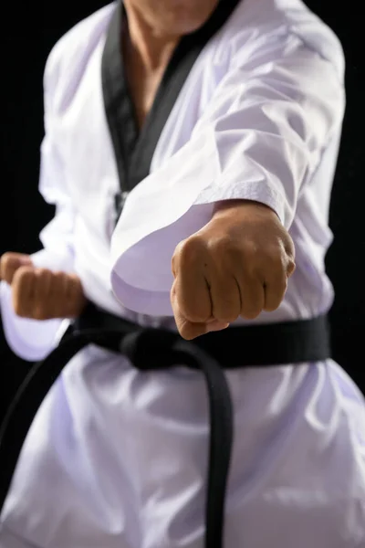 黒赤ベルトTaekwondo空手男性選手男ショー伝統的なファイティングポーズパンチオン黒背景閉じるアップでパンチ — ストック写真