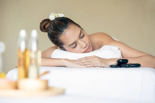 Young Asia Woman Lying and Relaxing in a Healthy Spa Bed for Skin Care and Serene Massage Therapy looking camera with copy space