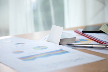 Stratejik planlama için not defteri, kalem ve tabletin yanı sıra iş raporları, renkli pasta grafikleri ve grafiklerle çalışma alanı
