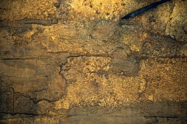 Değişen kahverengi tonlar ve çatlaklarla paslanmış ve desenli metal yüzeyin ayrıntılı görüntüsü