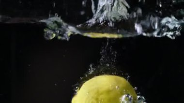 Limon düşüşü hareketi bulanıklaşır ve dramatik damlalar ve dalgalanmalarla suya düşer.