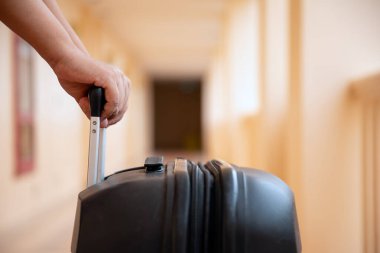 Siyah bavulu parlak otel koridorunda çekerken yakın plan, seyahat ya da tatil anlamına geliyor.