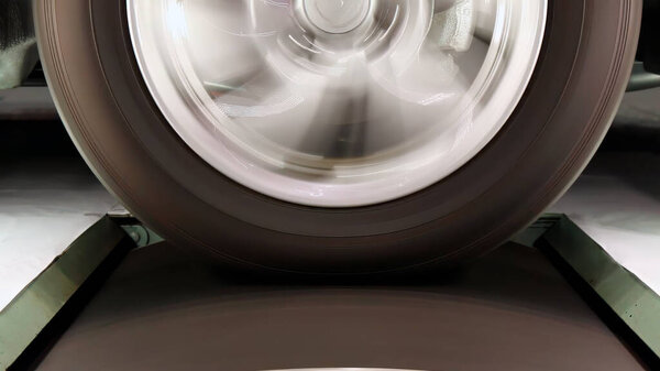 Крупный план вращающегося колеса транспортного средства с размытием колес и шин во время высокоскоростных испытаний. Измерение энергии и динамических характеристик вращательного фрикционного ролика в лаборатории