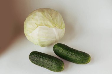Raw cucumbers and cabbage on white background clipart