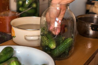 Kadın kış için sebze tuzluyor.