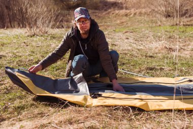 Adam kano gezisi için lastik bot şişiriyor.