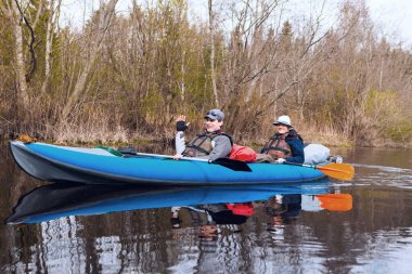 İki adam nehirde kayak yapıyor.