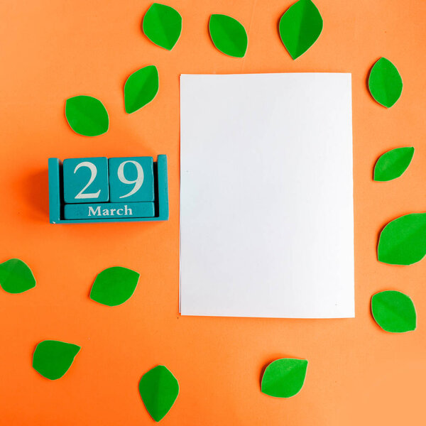 March 29. blue cube calendar and white mockup blank on bright orange background