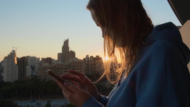 Junge Frau Mit Handy Gegen Das Morgendliche Stadtbild Sie Scrollt — Stockvideo