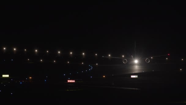 飞机上有侧灯和前灯 跑道上的出租车夜间点亮了侧灯 — 图库视频影像