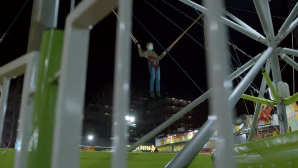 Nachtfoto Van Een Kind Dat Bungee Trampoline Springt Het Openluchtpretpark — Stockvideo