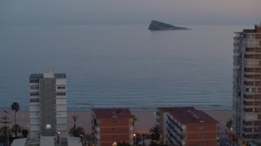 Alacakaranlıktaki Benidorm sahnesi. Kumsaldaki oteller, kıyıdan çok uzak olmayan adalı sakin deniz. Ada, İspanya 'nın doğal rezervi.