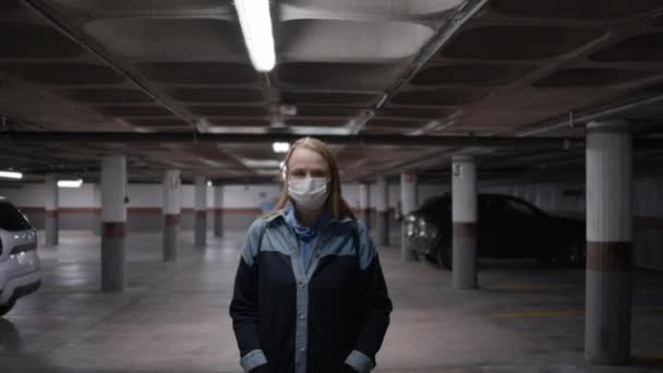Γυναίκα Στο Υπόγειο Πάρκινγκ Φοράει Μάσκα Και Κοιτάζει Την Κάμερα — Αρχείο Βίντεο