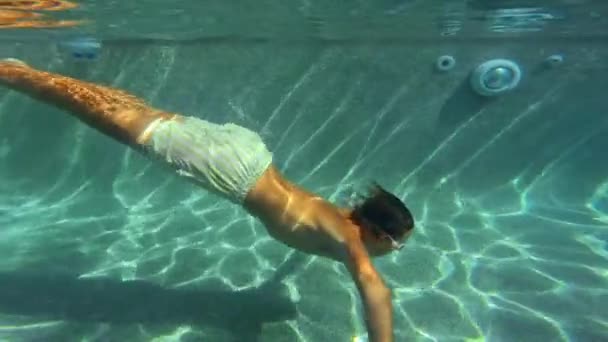慢动作 少年戴着护目镜在游泳池里游泳 红色镜片在水里 — 图库视频影像