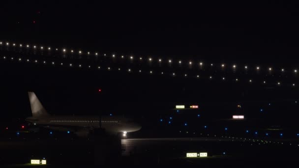 2人の旅客機がヘッドライトと駐車灯で動いています夜の離陸の準備をしています — ストック動画