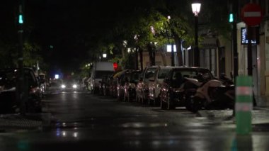VALENCIA, SPAIN - 21 EYLÜL 2022: Park halindeki arabalar gece şehrinin caddesinde duruyor, arabalar farları açık, sokak ışıkları parlıyor